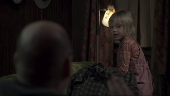 Movie still from “Trapped” (2002), directed by Luis Mandoki – A young girl sitting on a couch looking at a man; Medium shot, Over the shoulder angle