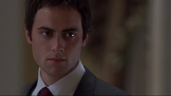 Movie still from “Trapped” (2002), directed by Luis Mandoki – A person wearing a suit and tie; Close Up shot, Low angle