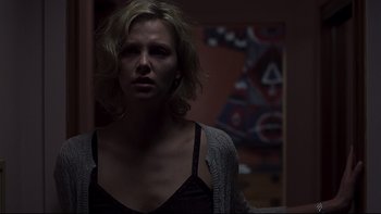 Movie still from “Trapped” (2002), directed by Luis Mandoki – A woman in a black shirt and a gray sweater; Medium shot, Low angle