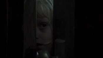 Movie still from “Trapped” (2002), directed by Luis Mandoki – A little girl is looking through the bars of a cage; Close Up shot, Low angle