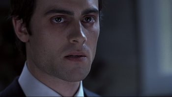 Movie still from “Trapped” (2002), directed by Luis Mandoki – A person wearing a suit and tie; Close Up shot, Low angle