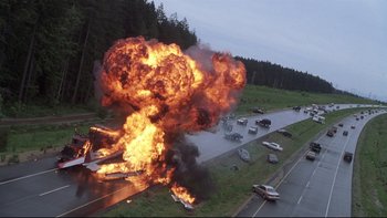 Movie still from “Trapped” (2002), directed by Luis Mandoki – An explosion on the side of a highway; Extreme Wide shot, High angle