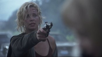 Movie still from “Trapped” (2002), directed by Luis Mandoki – A woman is holding a gun in her hand; Close Up shot, Over the shoulder angle