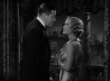 Movie still from “Trouble in Paradise” (1932), directed by Ernst Lubitsch – A man and a woman standing next to each other; Medium shot, High angle