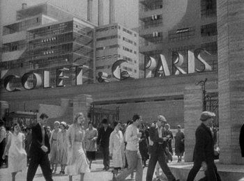 Movie still from “Trouble in Paradise” (1932), directed by Ernst Lubitsch – A black and white photo of a crowd of people walking down a street; Extreme Wide shot, Low angle