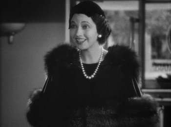 Movie still from “Trouble in Paradise” (1932), directed by Ernst Lubitsch – An old photo of a woman wearing a fur coat; Close Up shot, Over the shoulder angle