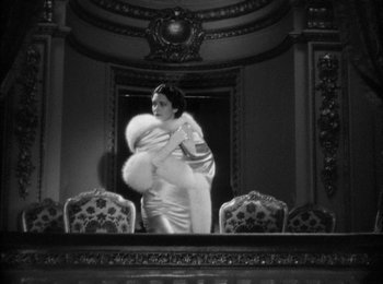 Movie still from “Trouble in Paradise” (1932), directed by Ernst Lubitsch – An old photo of a woman in a white dress; Medium shot, Low angle