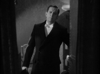 Movie still from “Trouble in Paradise” (1932), directed by Ernst Lubitsch – A black and white photo of a man in a tuxedo; Medium shot, Low angle