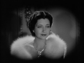 Movie still from “Trouble in Paradise” (1932), directed by Ernst Lubitsch – An old photo of a woman wearing a fur coat; Close Up shot, Low angle