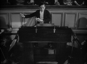 Movie still from “Trouble in Paradise” (1932), directed by Ernst Lubitsch – A man sitting in front of an organ in an auditorium; Wide shot, High angle