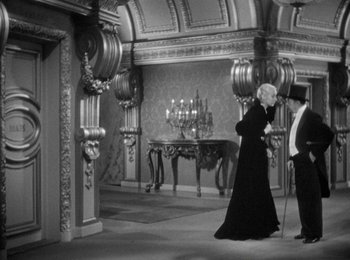 Movie still from “Trouble in Paradise” (1932), directed by Ernst Lubitsch – A man and a woman are standing in a room; Wide shot, High angle