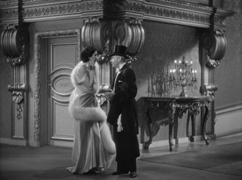 Movie still from “Trouble in Paradise” (1932), directed by Ernst Lubitsch – A man and a woman standing next to each other in a room; Wide shot, High angle