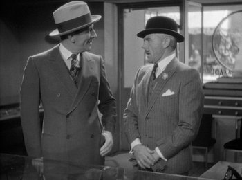 Movie still from “Trouble in Paradise” (1932), directed by Ernst Lubitsch – Two men in suits talking to each other; Medium shot, Over the shoulder angle