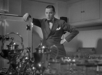 Movie still from “Trouble in Paradise” (1932), directed by Ernst Lubitsch – A black and white photo of a man in a suit; Medium shot, Low angle