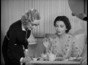 Movie still from “Trouble in Paradise” (1932), directed by Ernst Lubitsch – Two women sitting at a table with a plate of food; Medium shot, High angle