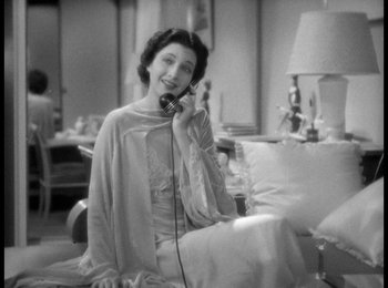 Movie still from “Trouble in Paradise” (1932), directed by Ernst Lubitsch – An old photo of a woman talking on a phone; Medium shot, High angle