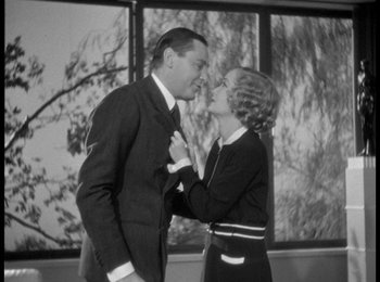 Movie still from “Trouble in Paradise” (1932), directed by Ernst Lubitsch – A man and a woman kissing in front of a window; Medium shot, Low angle