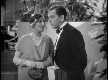 Movie still from “Trouble in Paradise” (1932), directed by Ernst Lubitsch – A man and a woman standing next to each other; Medium shot, High angle