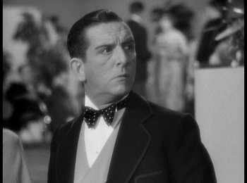 Movie still from “Trouble in Paradise” (1932), directed by Ernst Lubitsch – A man wearing a suit and a bow tie; Close Up shot, Low angle