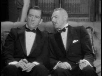 Movie still from “Trouble in Paradise” (1932), directed by Ernst Lubitsch – Two men in tuxedos sitting next to each other on a couch; Medium shot, Over the shoulder angle