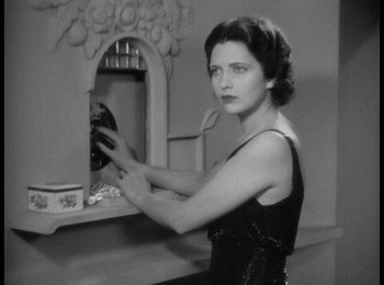 Movie still from “Trouble in Paradise” (1932), directed by Ernst Lubitsch – A black and white photo of a woman looking in a mirror; Medium shot, Low angle