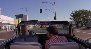Movie still from “Truck Turner” (1974), directed by Jonathan Kaplan – Two men riding in the back seat of a car; Wide shot, Low angle