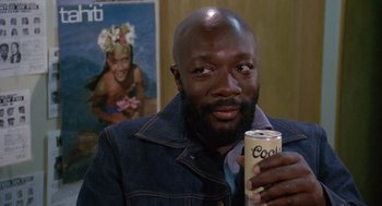 Movie still from “Truck Turner” (1974), directed by Jonathan Kaplan – A man in a denim jacket holding a can of soda; Close Up shot, Low angle