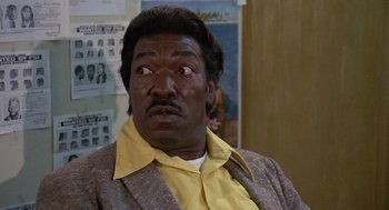 Movie still from “Truck Turner” (1974), directed by Jonathan Kaplan – A person wearing a suit and tie; Close Up shot, Low angle