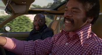 Movie still from “Truck Turner” (1974), directed by Jonathan Kaplan – Two men in the back seat of a car; Medium shot, Low angle