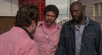 Movie still from “Truck Turner” (1974), directed by Jonathan Kaplan – A group of men standing next to each other; Medium shot, Over the shoulder angle