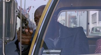 Movie still from “Truck Turner” (1974), directed by Jonathan Kaplan – A man in a taxi holding a gun in his hand; Close Up shot, Low angle