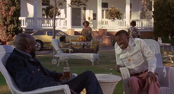 Movie still from “Truck Turner” (1974), directed by Jonathan Kaplan – A group of people sitting in a yard; Wide shot, High angle