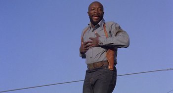 Movie still from “Truck Turner” (1974), directed by Jonathan Kaplan – A man holding a holster in his hand; Medium shot, Low angle