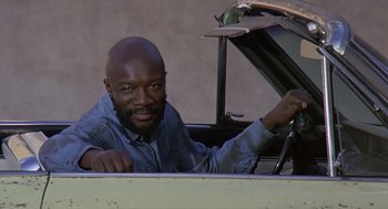 Movie still from “Truck Turner” (1974), directed by Jonathan Kaplan – A man sitting in the driver's seat of a car; Medium shot, Low angle