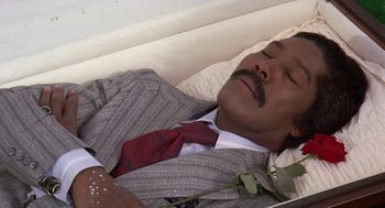 Movie still from “Truck Turner” (1974), directed by Jonathan Kaplan – A man laying in a bed with a rose in his hand; Close Up shot, Overhead angle