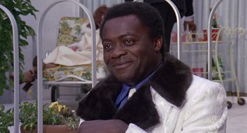 Movie still from “Truck Turner” (1974), directed by Jonathan Kaplan – A man in a white jacket and a fur collar; Close Up shot, Over the shoulder angle