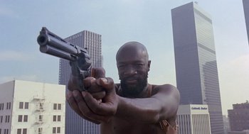 Movie still from “Truck Turner” (1974), directed by Jonathan Kaplan – A man holding a gun in his hands; Close Up shot, Low angle