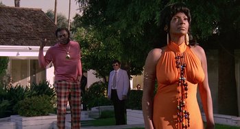 Movie still from “Truck Turner” (1974), directed by Jonathan Kaplan – A man and a woman standing next to each other on a sidewalk; Medium shot, Low angle