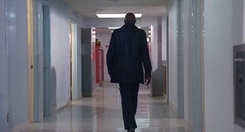 Movie still from “Truck Turner” (1974), directed by Jonathan Kaplan – A man walking down a hall way wearing a suit; Wide shot, Low angle