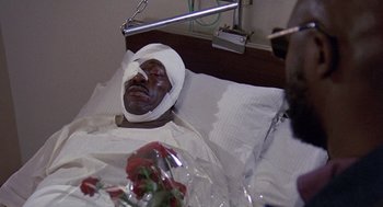 Movie still from “Truck Turner” (1974), directed by Jonathan Kaplan – A man with a bandage on his head is laying in a hospital bed; Close Up shot, High angle