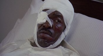 Movie still from “Truck Turner” (1974), directed by Jonathan Kaplan – A man with bandages on his head is laying in a bed; Close Up shot, High angle