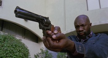 Movie still from “Truck Turner” (1974), directed by Jonathan Kaplan – A man holding a gun up to his face; Close Up shot, Low angle