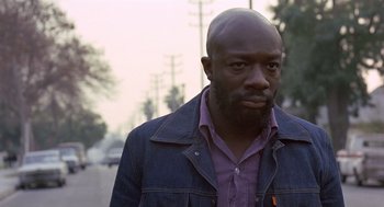 Movie still from “Truck Turner” (1974), directed by Jonathan Kaplan – A black man with a purple shirt is looking at the camera; Close Up shot, Low angle