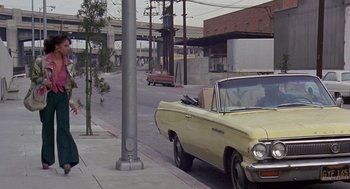 Movie still from “Truck Turner” (1974), directed by Jonathan Kaplan – An old car parked on the side of the street; Wide shot, High angle