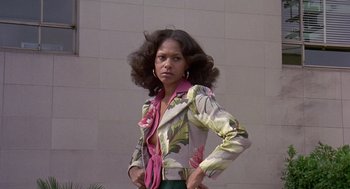 Movie still from “Truck Turner” (1974), directed by Jonathan Kaplan – A woman in a floral jacket and green pants; Medium shot, Low angle