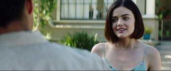 Movie still from “Truth or Dare” (2018), directed by Jeff Wadlow – A beautiful young lady sitting in front of a building; Close Up shot, Over the shoulder angle