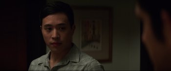 Movie still from “Truth or Dare” (2018), directed by Jeff Wadlow – A man in a plaid shirt is standing in front of a painting; Close Up shot, Over the shoulder angle