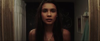 Movie still from “Truth or Dare” (2018), directed by Jeff Wadlow – A woman with long black hair is looking at the camera; Close Up shot, Low angle