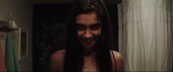 Movie still from “Truth or Dare” (2018), directed by Jeff Wadlow – A woman with long black hair smiling for the camera; Close Up shot, High angle