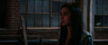 Movie still from “Truth or Dare” (2018), directed by Jeff Wadlow – A woman with long black hair looking to her left; Close Up shot, Over the shoulder angle